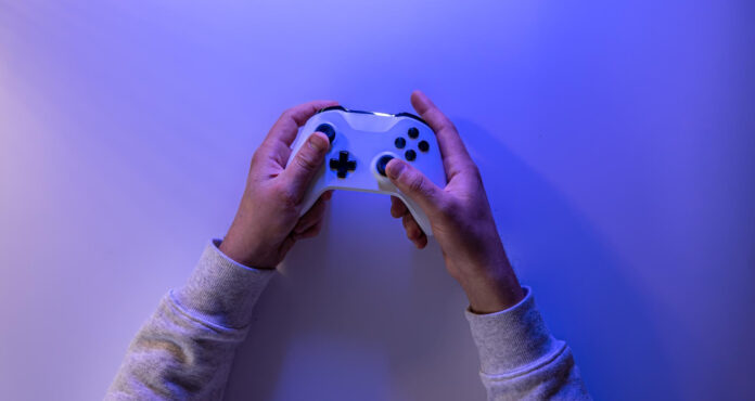 Nell'immagine due mani stanno giocando con un gamepad - Smart Marketing