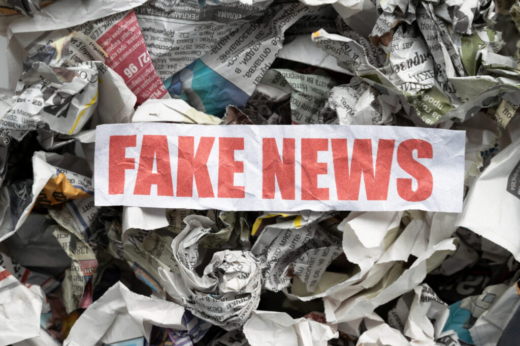 Nell'immagine una serie di giornali accartocciati con la scritta Fake News - Smart Marketing