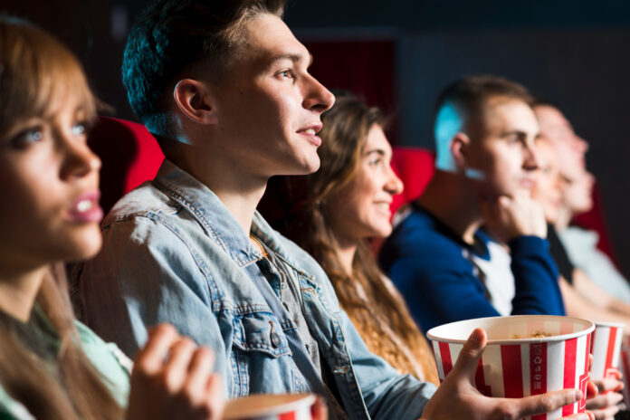 Nell'immagine dei ragazzi guardano un film al cinema e mangiano dei popcorn - Smart Marketing